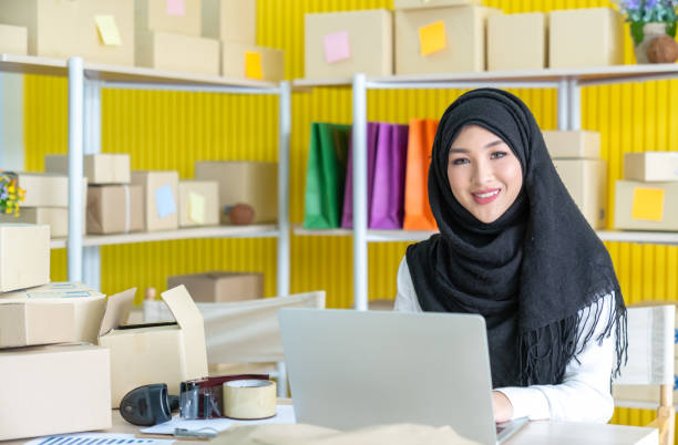 Young asian muslim woman in hijab dress is working stock photo