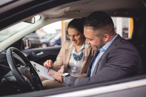 istock Young man buys a car on a car lot 1192922600