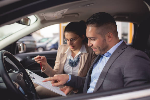 istock Young man buys a car on a car lot 1192922628
