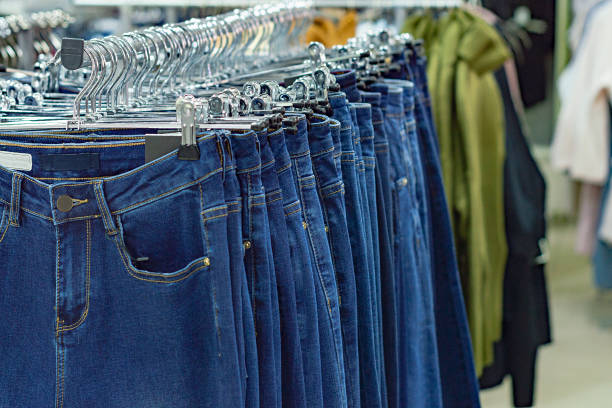 istock Rows of blue jeans on hangers. 1192922816