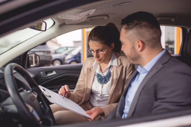 istock Young man buys a car on a car lot 1192922842
