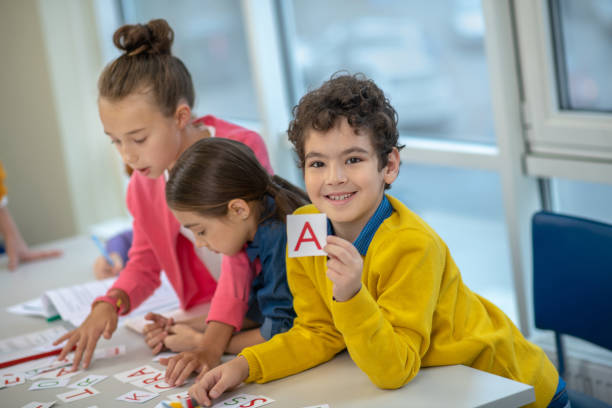 istock Smiling schoolboy holding a card with the letter A 1192924250
