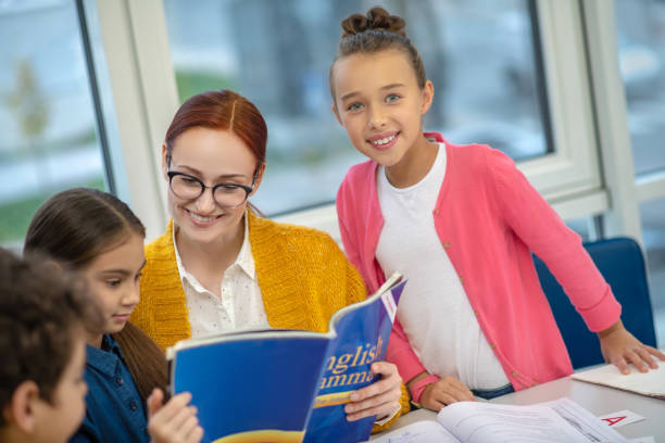 istock Good-looking teacher explaining grammar to her students 1192924262