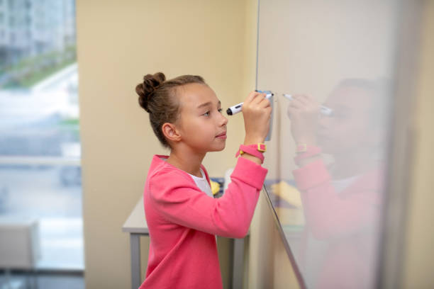 istock Girl meticulously writing letters on the whiteboard 1192924692