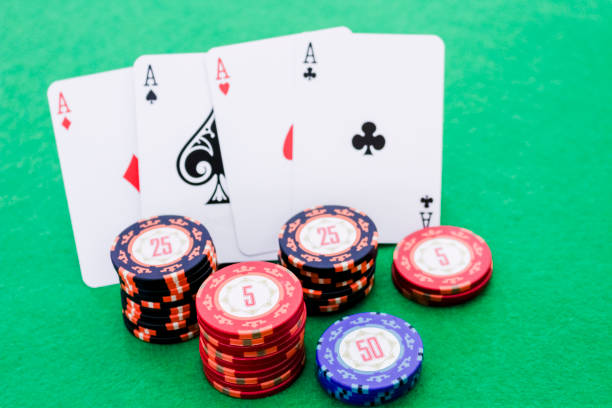 istock Stack of poker chips and four cards with aces on green background, selective focus 1192925843