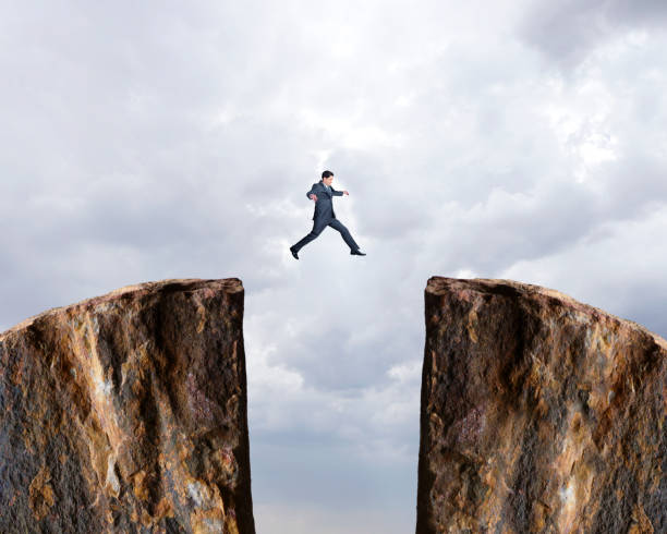 istock Businessman Jumps From One Cliff To Another 1192927902