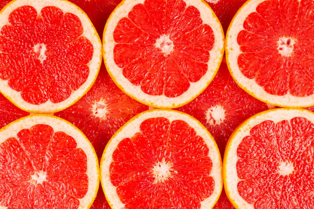 istock Grapefruit red juicy slices background. top view 1192930154