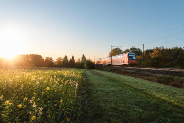 日の出の赤い列車と春の風景。春の旅行コンテキスト - train public transportation passenger train locomotive ストックフォトと画像