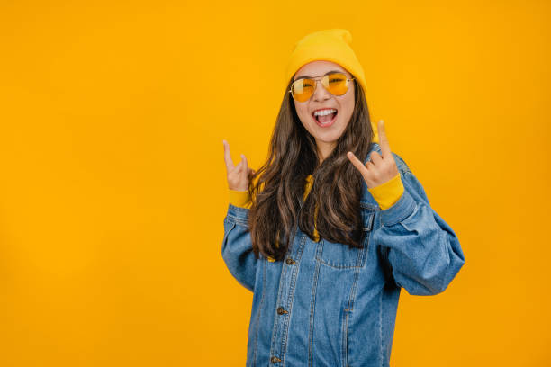 istock Young woman over isolated yellow background making rock gesture 1192932604
