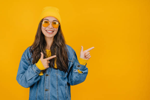 istock Young lady standing isolated over yellow background and pointing 1192933128