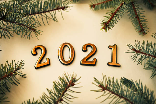 istock 2021 year golden figures and spruce branch  on a white background. 1192933984