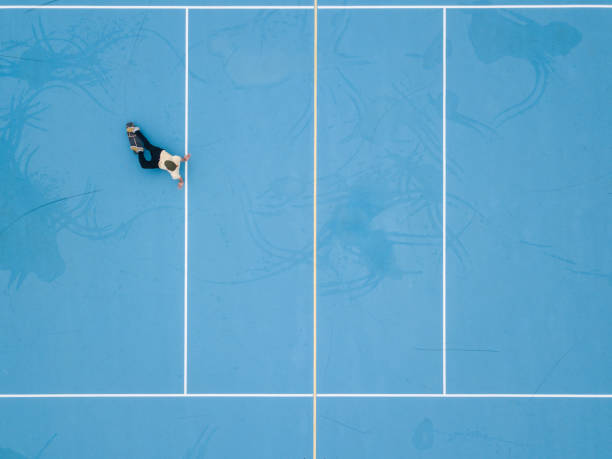 istock Man sliding a skateboard on blue school yard 1192934916