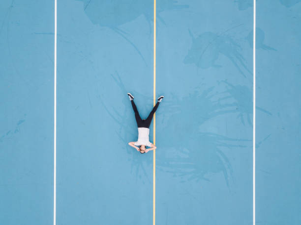 istock Woman lying on her back on blue school yard 1192934962
