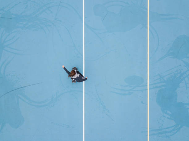 donna che fa skateboard nel cortile della scuola blu - skateboard court foto e immagini stock