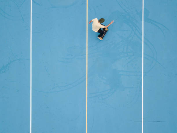 istock Skateboarding on blue school yard 1192935056