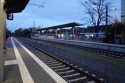 Kleinenbroich, Germany, November 21, 2019: Kleinenbroich S-Bahn Station with some unidentified people in the background. The Kleinenbroich railway station is located on the Moenchengladbach - Duesseldorf railway line. The reception building, built in 1851, is listed as a monument in the list of architectural monuments in Korschenbroich.