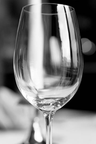 close-up vazio da wineglass em um fundo do restaurante do feriado. esperando o feriado. imagem em preto e branco - champagne flute champagne black wineglass - fotografias e filmes do acervo