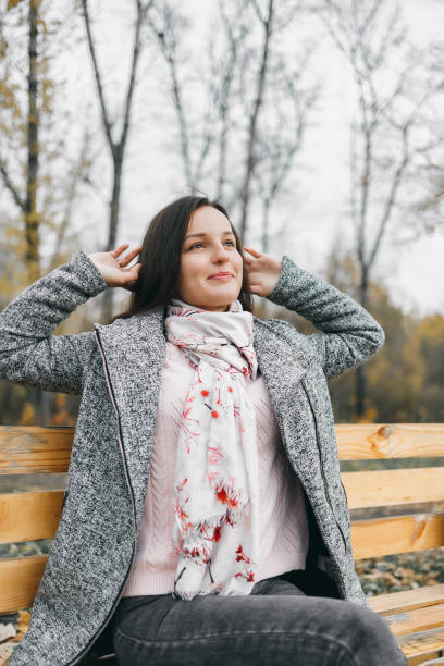 istock Girl in autumn sits on a bench 1192938159
