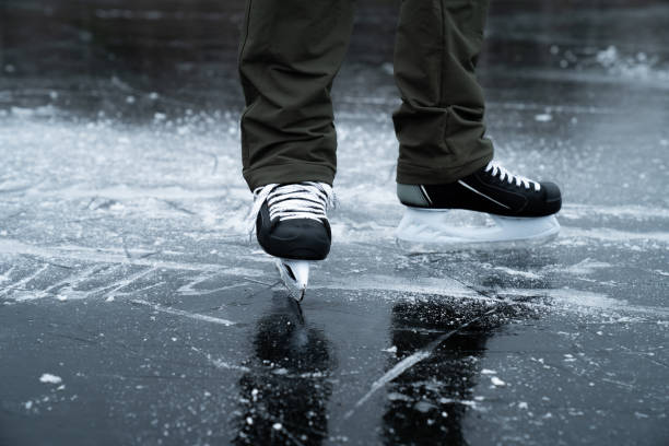 istock Man's legs in skates on frozen lake ice 1192940887