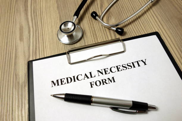 istock Medical necessity form with pen and stethoscope 1192940919