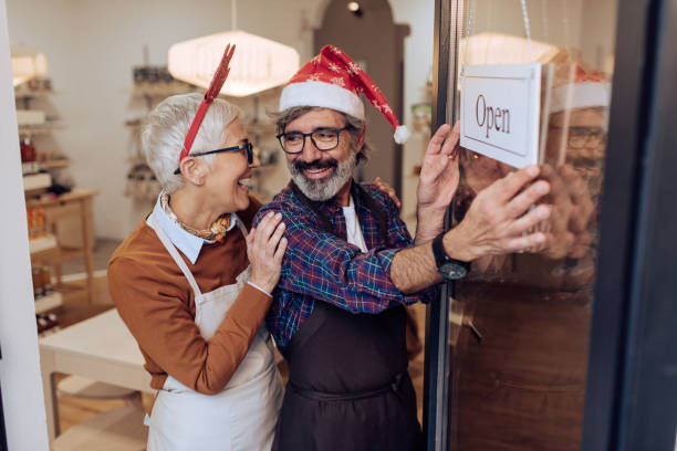 mature couple opening their store for christmas - sales clerk store manual worker retail imagens e fotografias de stock