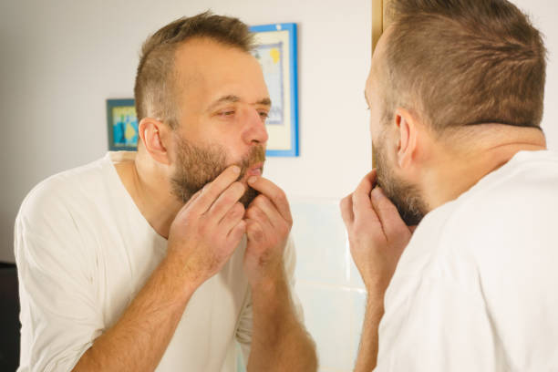 istock Man looking at pimples on his face 1192941034