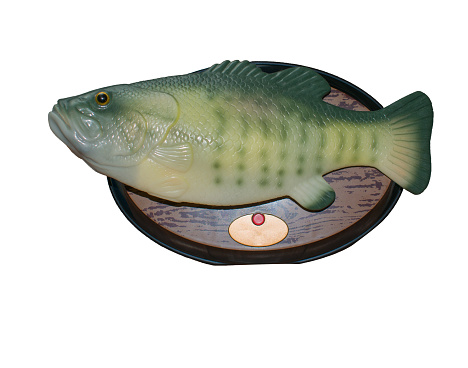 Isolated souvenir fish on white background. Musical toy on board.