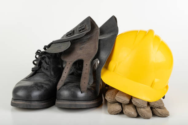 istock Helmet, work boots and gloves on a white table. Workwear for the production worker. Light background. 1192943198