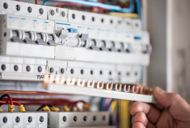 istock Man, an electrical technician working in a switchboard with fuses. Installation and connection of electrical equipment. Close up. 1192947294