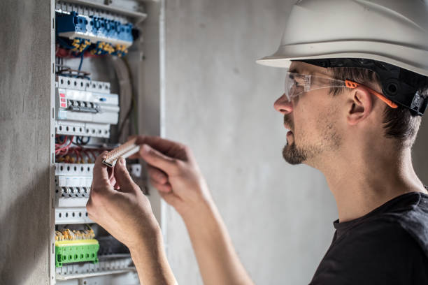 istock Man, an electrical technician working in a switchboard with fuses. Installation and connection of electrical equipment. 1192947314