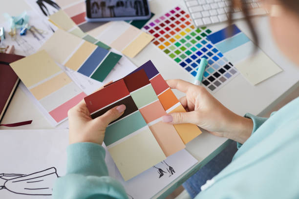 istock Over shoulder view of unrecognizable designer sitting at table and watching bring color palettes while comparing it 1192947491