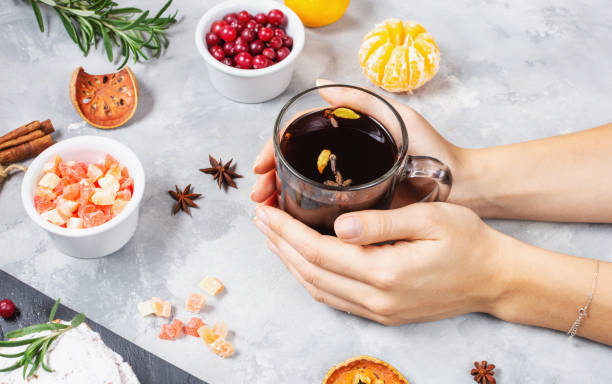 istock Female hands hold a cup of mulled wine on concrete background. 1192947552