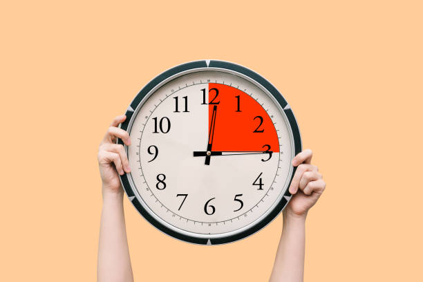 a black and white watch in the hands of a woman, showing the time of three hours a day or night. the time period is marked in red - minute hand fotos imagens e fotografias de stock