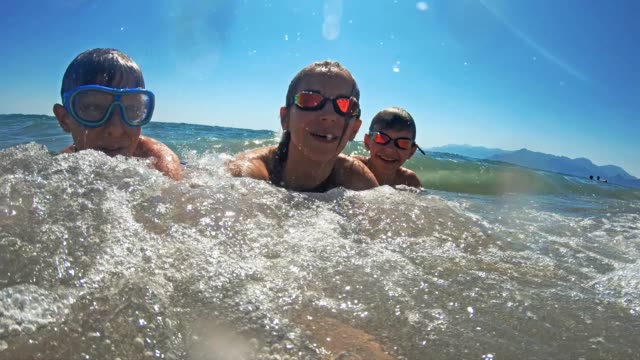 Brothers and sister having fun splashed in sea