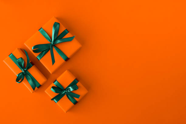 regalo presente cajas sobre fondo naranja. estaba plano. vista superior con espacio para texto - gift orange green package fotografías e imágenes de stock
