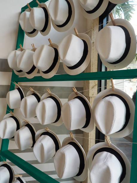 Hat rack display with rows of white straw woven hats stock photo