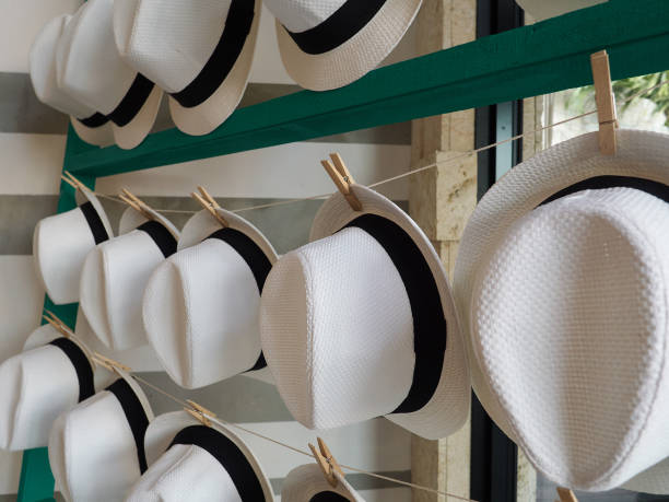 Hat rack display with rows of white straw woven hats stock photo