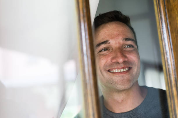istock Smiling man looking out the window 1192962975