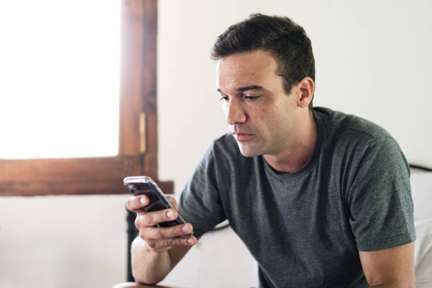 homem na teleconferência no smartphone - hotel wireless technology bedroom hotel room - fotografias e filmes do acervo