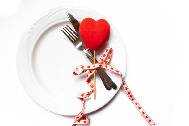 Festive restaurant table set for Valentines with red heart top view flat lay on white background