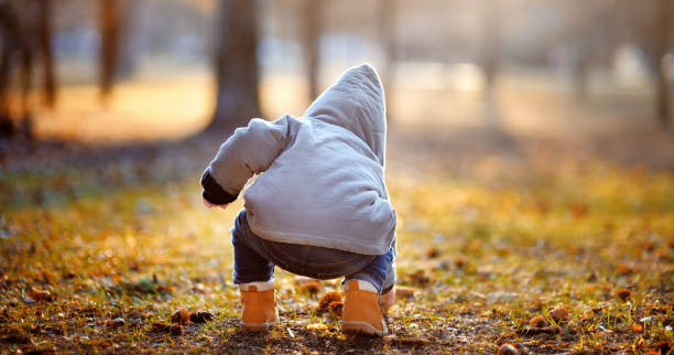 Toddler boy playing outdoors at the warm autumn day