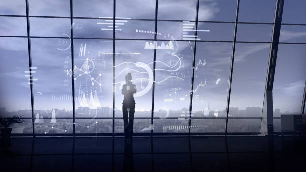 istock Business woman surrounded by virtual array of infographic data. 1192969432