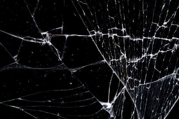 istock cracked glass isolated on a black background. 1192980415