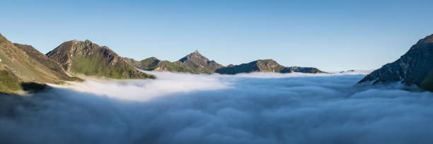 Panoramic view of beautiful cloud inversion, observed at sunrise from Cabane de Moiry in Swiss Alps. stock photo