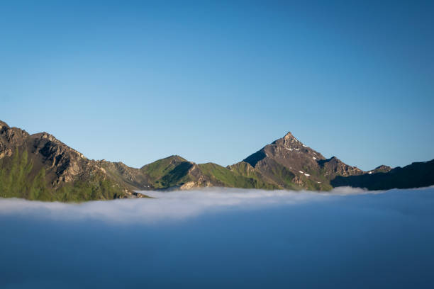Crisp, cold morning with beautiful cloud inversion, observed from Cabane de Moiry in Swiss Alps. stock photo
