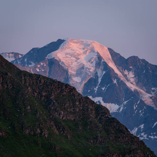 Close up image made at sunrise near Cabane Mont Fort in Swiss Alps. Ice capped mountain peak glows in orange. stock photo