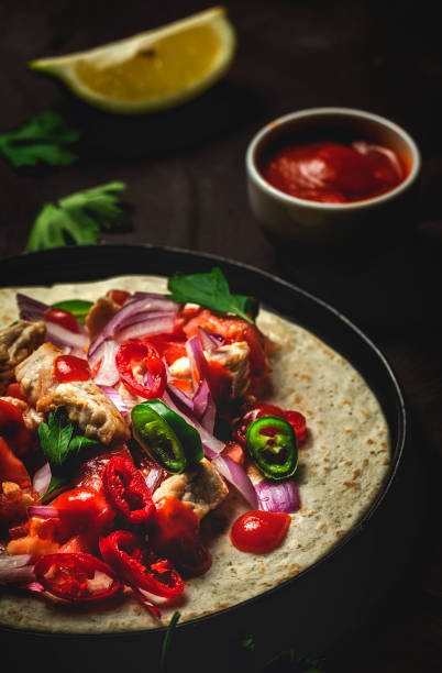 Homemade Mexican Tacos with fresh vegetables and chicken on brown background. Healthy food .Burritos.