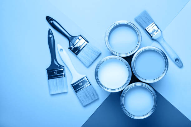 istock Four open cans of paint with brushes on bright background. 1192994548