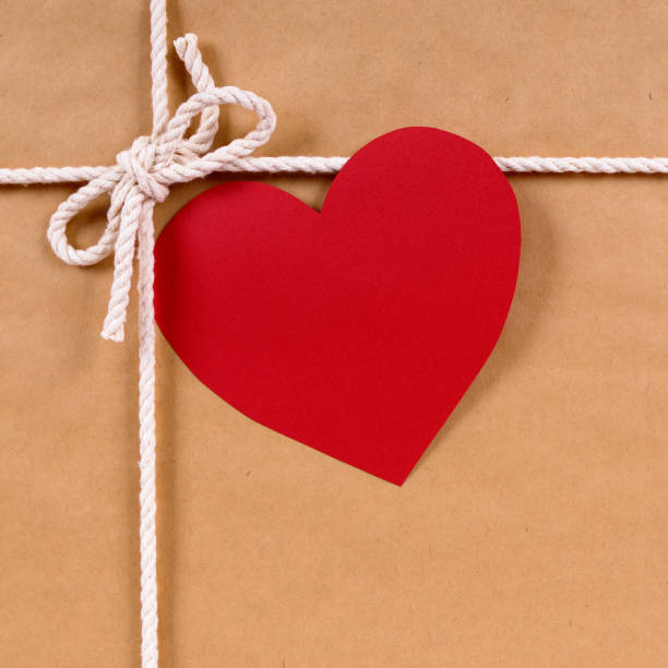 istock Valentines day gift with gift tag, brown paper package parcel background 1192995404