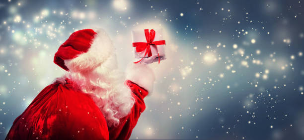 istock Santa holding a Christmas gift 1192999458